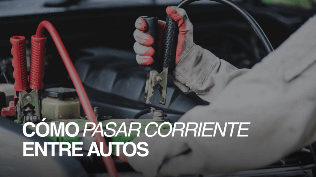 Primer plano de cables pasa corriente conectados a una batería; guía sobre cómo pasar batería de un auto a otro de forma segura.